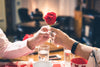 hands of senior couple holding a rose together over a Valentine's dinner.