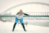 senior man stretching outside during winter. snow is on the ground.